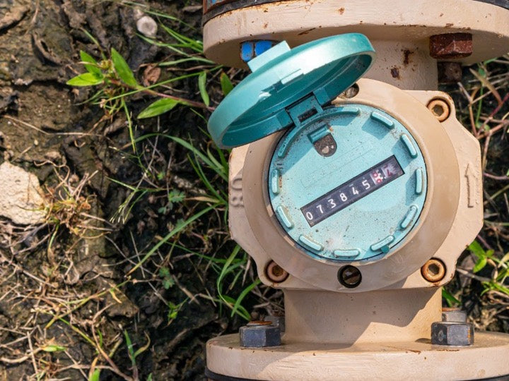 A utility water meter with its register lid open